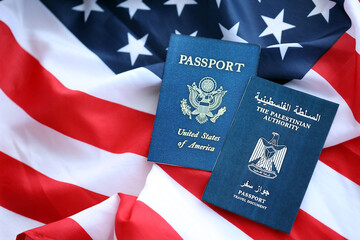 Passport of Palestinian Authority with US Passport on United States of America folded flag close up