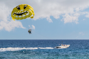 Parasailing in the sea. A popular tourist pastime with a parasailing parachute attached to a motorboat