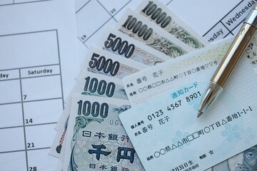 Japanese my number card specimen and notification card on calendar background with money close up