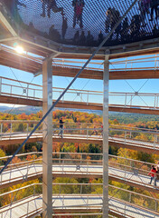 Inside a panoramic tower. Footbridge and observation tower in autumn. High platform for viewing forests and mountains. Access road to summit, wooden bridge in park. Building structure.