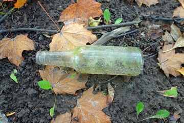 The transparent juice bottle discarded is on the ground