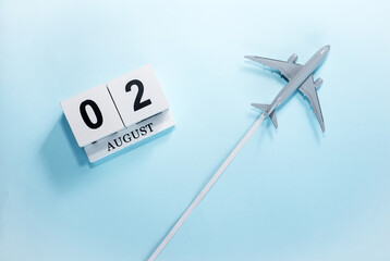 August calendar with number  2. Top view of a calendar with a flying passenger plane. Scheduler. Travel concept. Copy space.