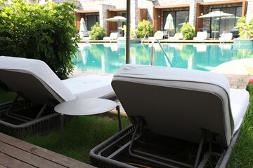 Sunbeds near outdoor swimming pool at luxury resort