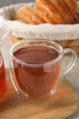 Aromatic tea in glass cup on table, closeup