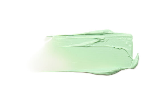 Strokes of green color correcting concealer isolated on white, top view