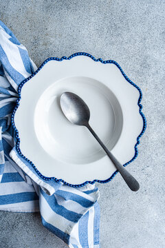 Elegant white plate with vintage spoon on concrete