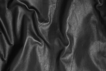 Texture of crumpled black leather as background, top view