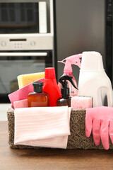 Different cleaning supplies in basket on table