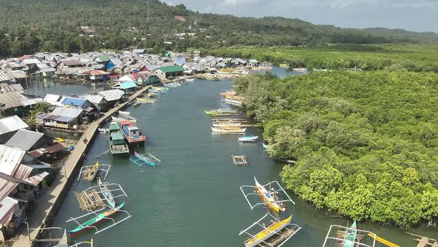 Aerial video of boats anchored in the sea near wooden houses in a fishing village, Socorro