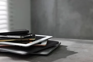  Many different modern gadgets on grey table indoors. Space for text © New Africa