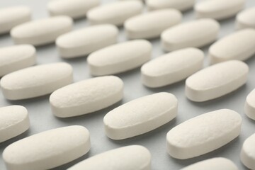 Fototapeta na wymiar Vitamin pills on light grey background, closeup. Health supplement