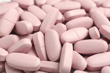 Many pink vitamin capsules as background, closeup
