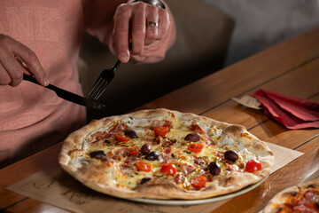 Man cutting pizza in restaurant