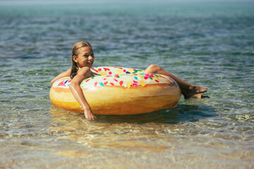 Teen Girl Sitting on a Donut in the Water