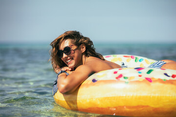 Woman Laying on Inflatable Donut in the Ocean