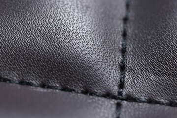 Purple leather with seam as background, closeup