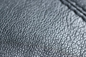 Black leather with seam as background, closeup