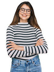 Young beautiful teen girl wearing casual clothes and glasses happy face smiling with crossed arms...