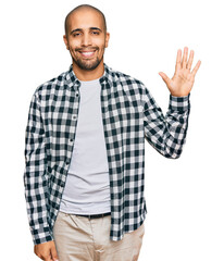 Naklejka premium Hispanic adult man wearing casual clothes showing and pointing up with fingers number five while smiling confident and happy.