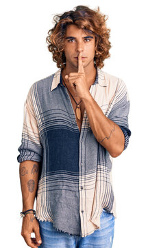 Young hispanic man wearing summer style asking to be quiet with finger on lips. silence and secret concept.