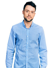 Hispanic man with beard wearing casual business shirt relaxed with serious expression on face. simple and natural looking at the camera.