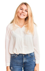 Young beautiful blonde woman wearing casual shirt looking positive and happy standing and smiling with a confident smile showing teeth
