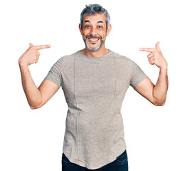 Middle age hispanic with grey hair wearing casual grey t shirt looking confident with smile on...