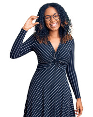 Young african american woman wearing casual clothes and glasses smiling and confident gesturing with hand doing small size sign with fingers looking and the camera. measure concept.