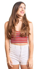 Fototapeta premium Beautiful caucasian young woman wearing casual clothes looking away to side with smile on face, natural expression. laughing confident.