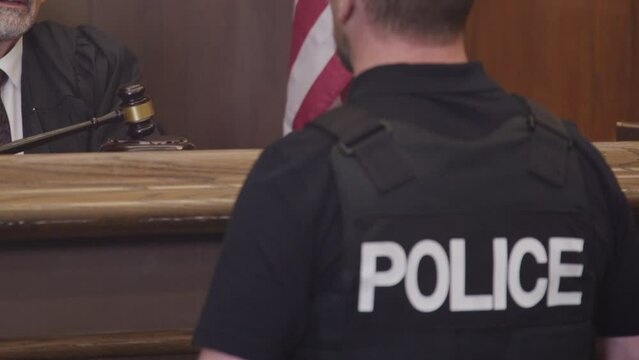 Stable shot of cop and judge in court room