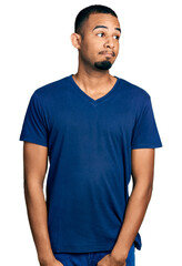 Young african american man wearing casual t shirt smiling looking to the side and staring away thinking.