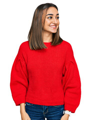 Beautiful brunette woman wearing casual winter sweater looking away to side with smile on face, natural expression. laughing confident.