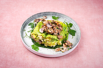 Traditional savoy cabbage lasagne with mashed potatoes and mushrooms served as a close-up on a design plate with text space