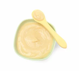 Fotobehang Tasty baby food in bowl and spoon isolated on white, top view © New Africa