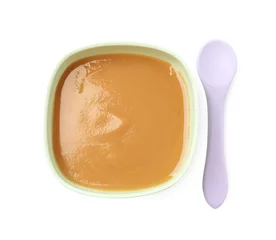 Fotobehang Tasty baby food in bowl and spoon isolated on white, top view © New Africa