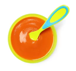 Schilderijen op glas Delicious baby food and spoon in bowl isolated on white, top view © New Africa