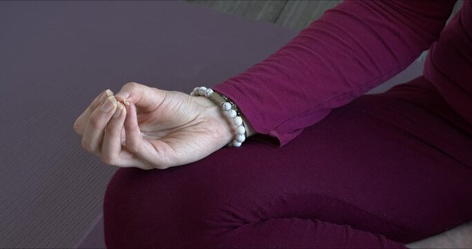 Woman doing mukula mudra hand meditation  gesture.