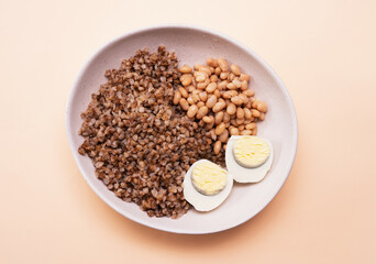 Top view, boiled buckwheat in a plate with a boiled egg, healthy food, porridge in a plate. Fitness food for weight loss. Protein with yolk.