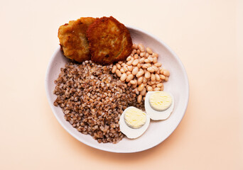 Top view, boiled buckwheat in a plate with a boiled egg, healthy food, porridge in a plate. Fitness food for weight loss. Protein with yolk.