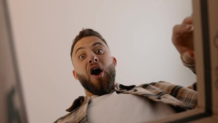 Unique perspective of an overjoyed man opening a delivery box. Captures the anticipation and excitement of receiving a new purchase.
