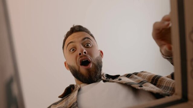 Unique perspective of an overjoyed man opening a delivery box. Captures the anticipation and excitement of receiving a new purchase.