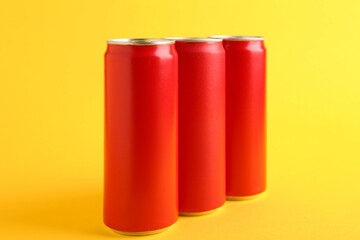 Energy drinks in red cans on yellow background