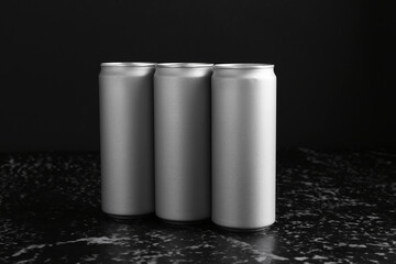 Energy drinks in cans on black textured table