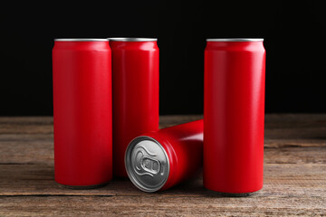 Energy drinks in red cans on wooden table