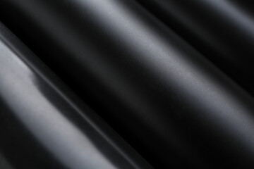 Energy drinks in black cans as background, closeup