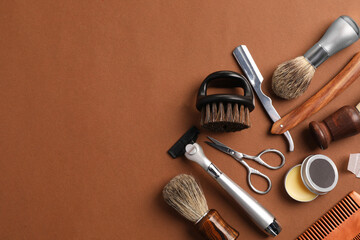 Moustache and beard styling tools on brown background, flat lay. Space for text