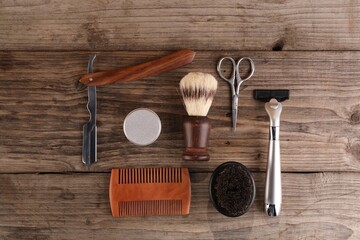 Moustache and beard styling tools on wooden table, flat lay