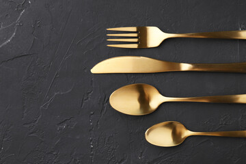 Beautiful cutlery set on black table, flat lay. Space for text