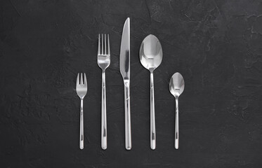Beautiful cutlery set on black table, flat lay