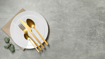 Stylish setting with elegant cutlery on grey table, top view. Space for text